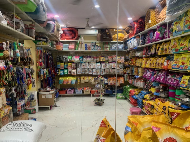 Store aisle lined with pet food, accessories and supplies.